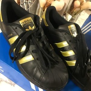 Black & gold Adidas Superstars